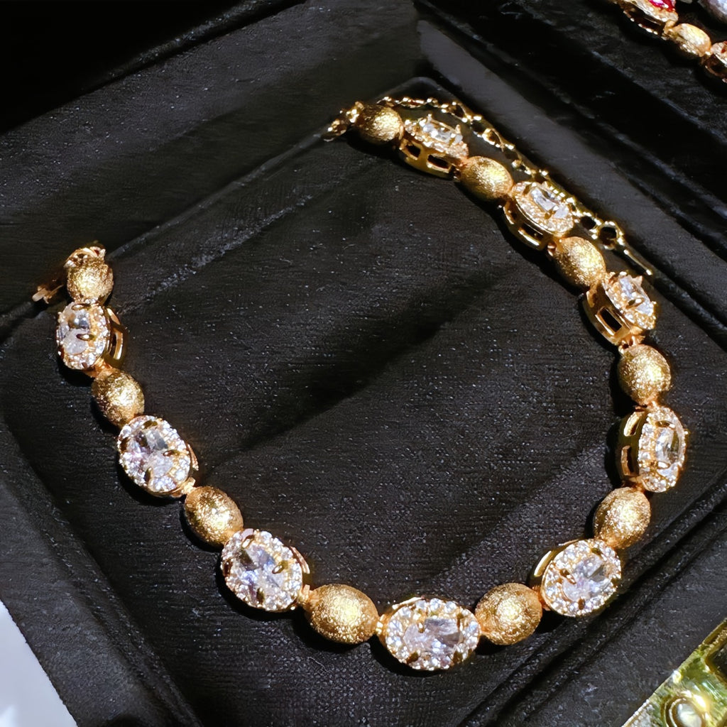 Bracelet: 18K gold plated brushed oval beads with clear cubic zirconia, second view
