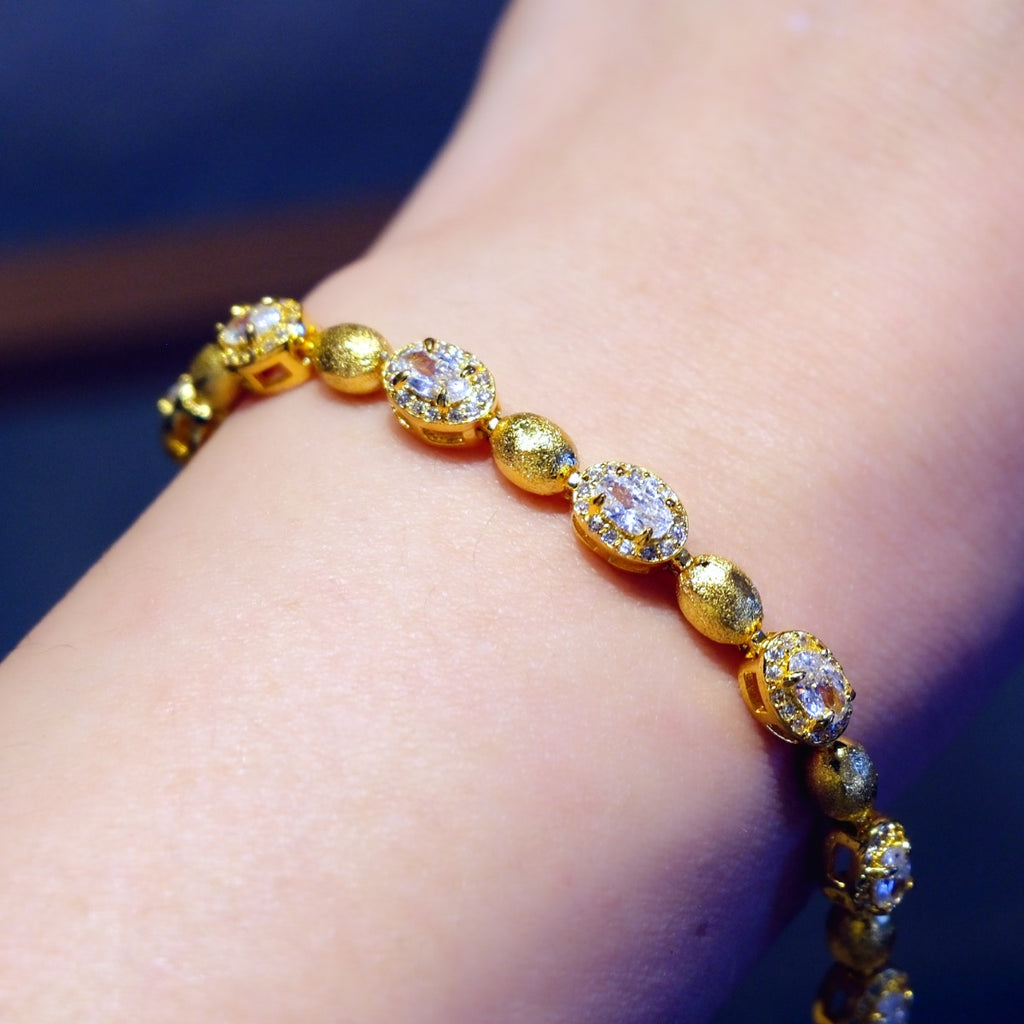 Bracelet: 18K gold plated brushed oval beads with clear cubic zirconia, third view