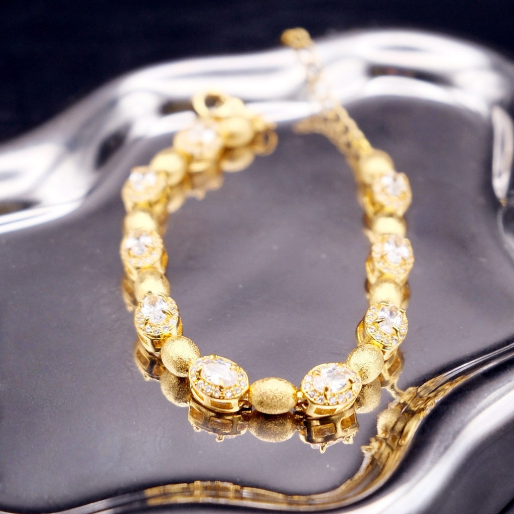 Bracelet: 18K gold plated brushed oval beads with clear cubic zirconia, fifth view