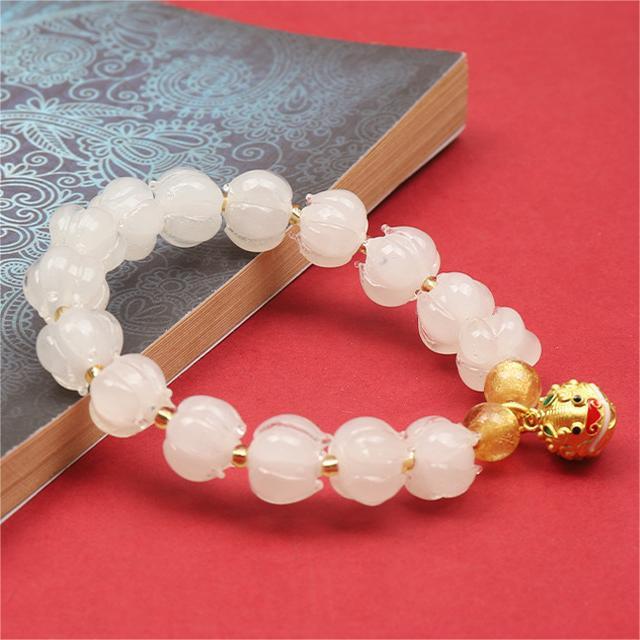 Bracelet: translucent pale white lotus-shaped liuli glass beads with a charm, second view