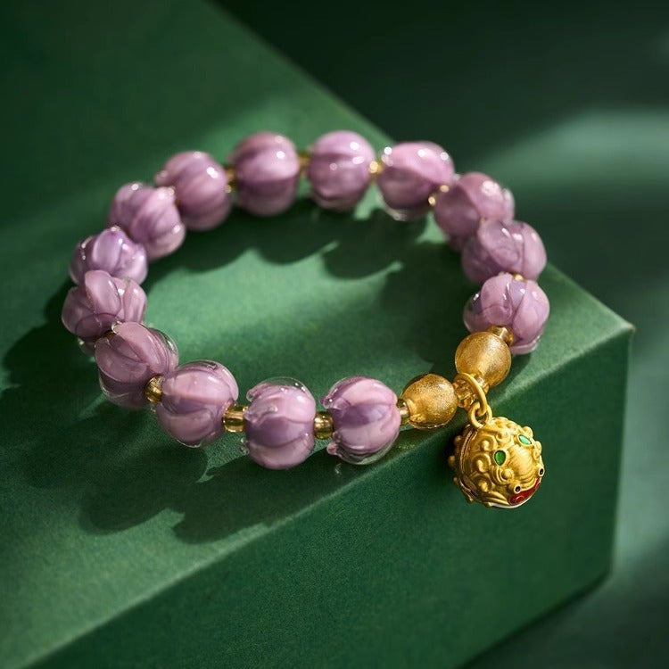 Bracelet: dusky lavender lotus-shaped liuli glass beads with a gold-coloured Tunjin beast charm