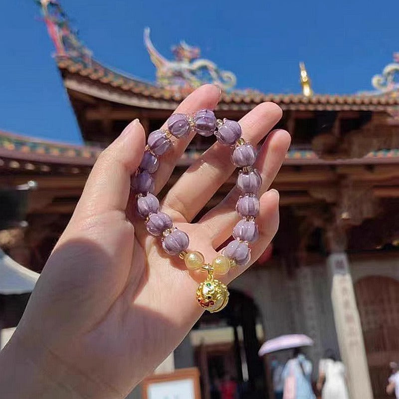 Bracelet: dusky lavender lotus-shaped liuli glass beads with a Tunjin beast charm, fourth view