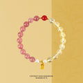 Bracelet: pink strawberry quartz, pale yellow citrine and small white pearl beads with a red bead and gold charm