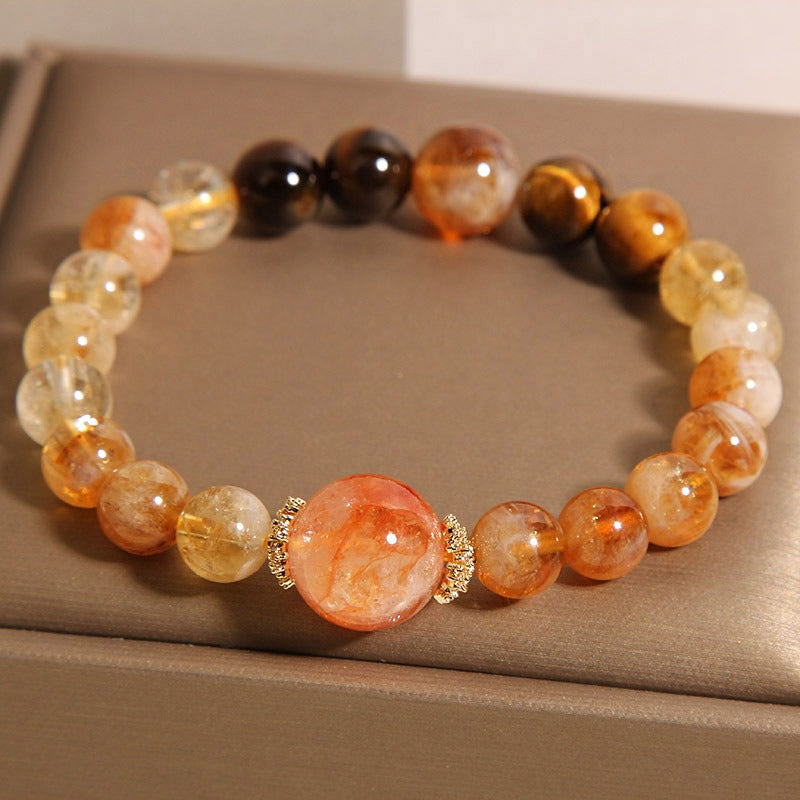 Bracelet: golden rutilated quartz beads, banded brown cat's eye beads and a large orange-red centre bead