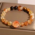 Bracelet: golden rutilated quartz beads, banded brown cat's eye beads and a large orange-red centre bead