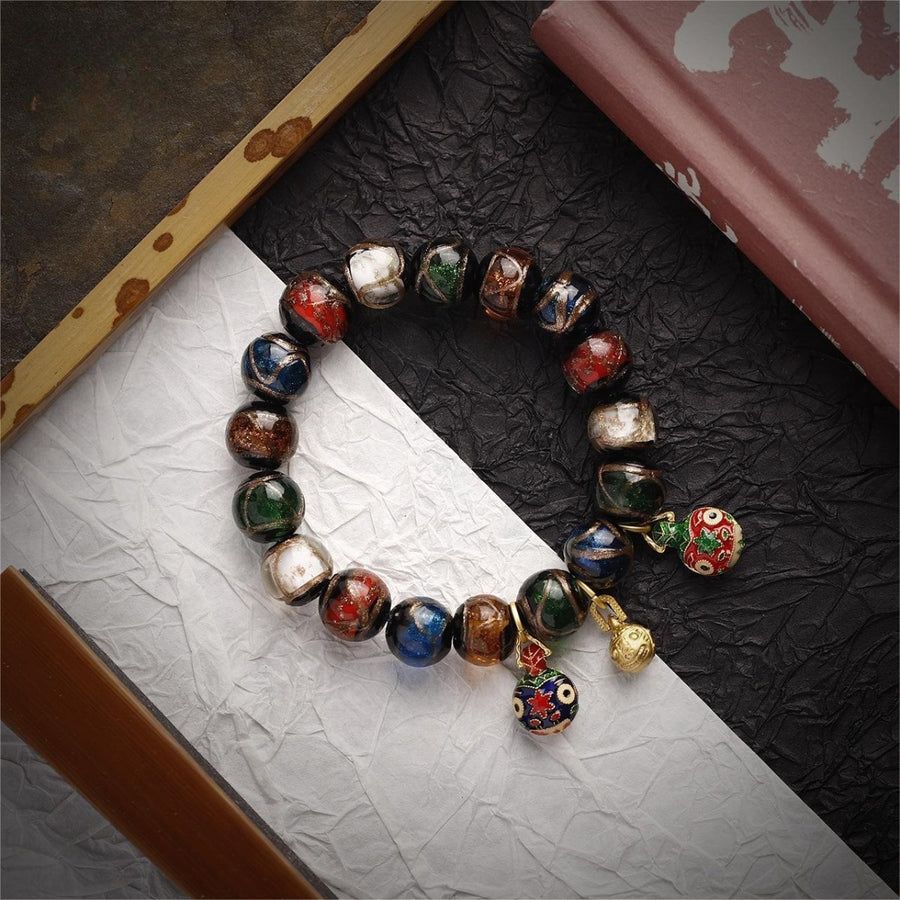 Bracelet: dark liuli glass beads in red, blue, green, white and brown with three small round charms