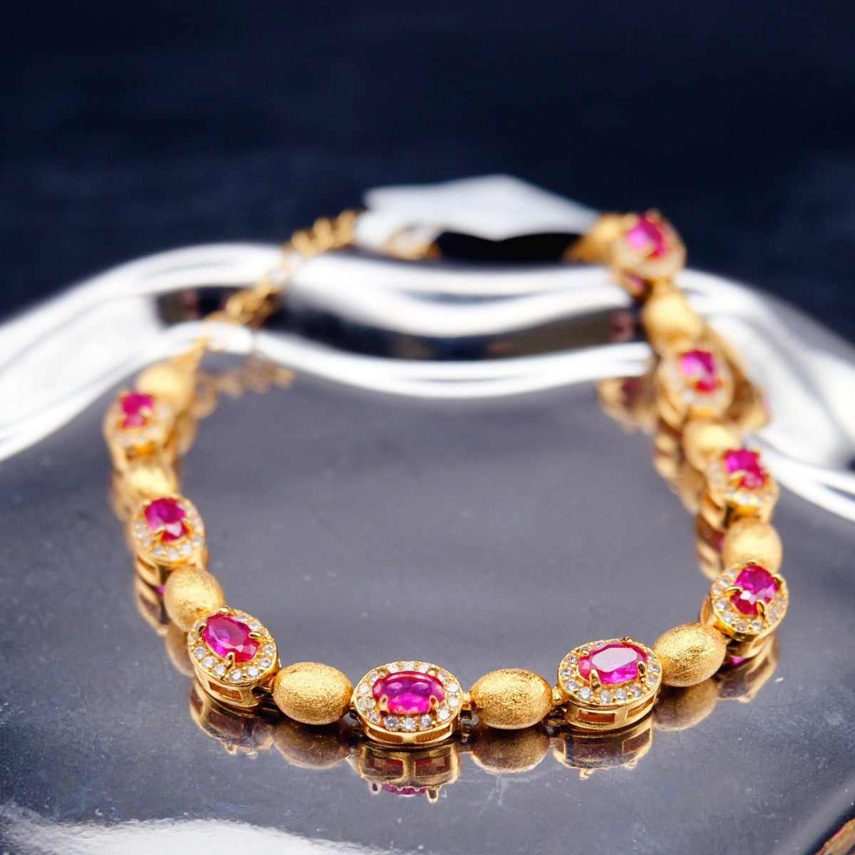 Bracelet: 18K gold plated oval beads with lab-created ruby stones in halos, fourth view