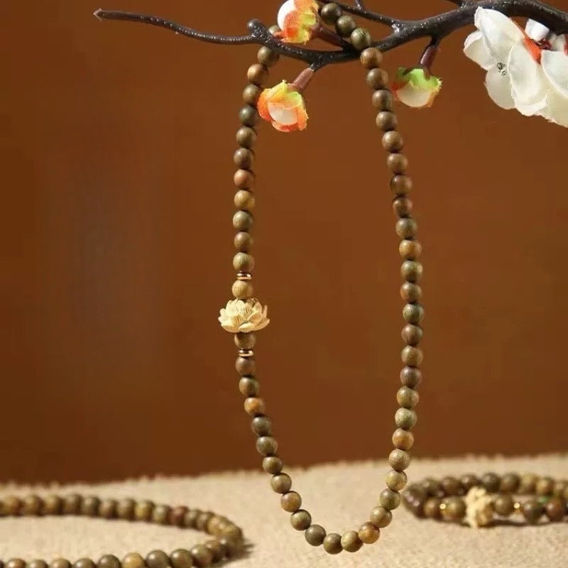 Bracelet: double wrap of green-brown sandalwood beads with a boxwood lotus, second view