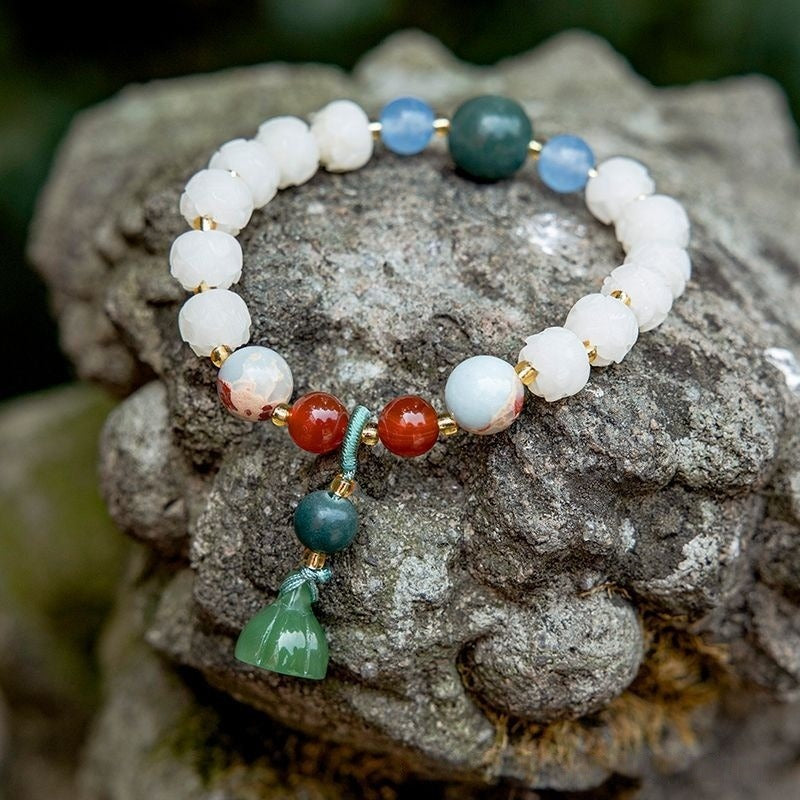 Bracelet: white lotus-petal bodhi root beads with blue, green and red accent beads and a green lotus bell