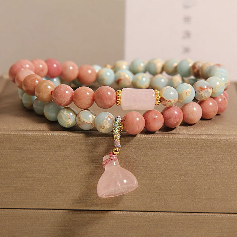 Bracelet: two strands of pink rhodonite and pale blue-cream beads with a lotus pod pendant, second view