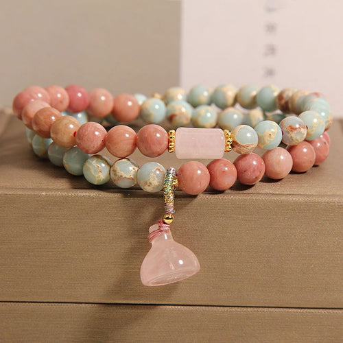 Bracelet: two strands of pink rhodonite and pale blue-cream beads with a lotus pod pendant, second view