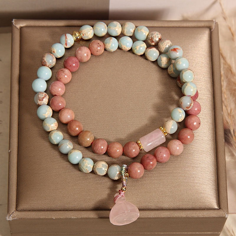 Bracelet: two strands of pink rhodonite and pale blue-cream beads with a lotus pod pendant, third view