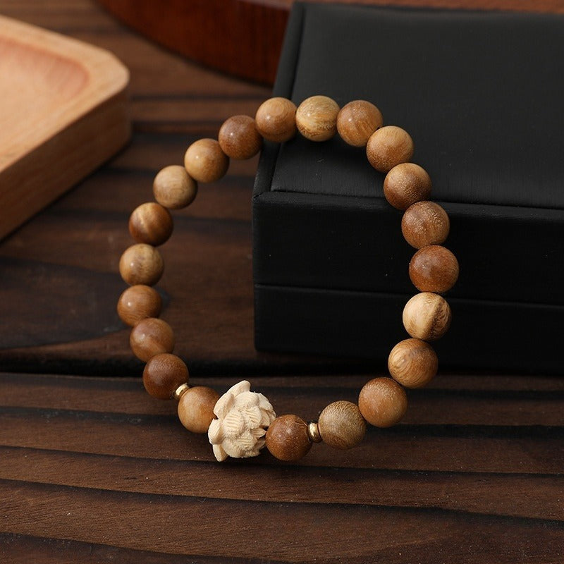 Bracelet: light brown green sandalwood beads with a cream carved boxwood lotus bead