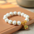 Bracelet: milky white lotus-shaped liuli glass beads with a gold-coloured Tunjin beast charm
