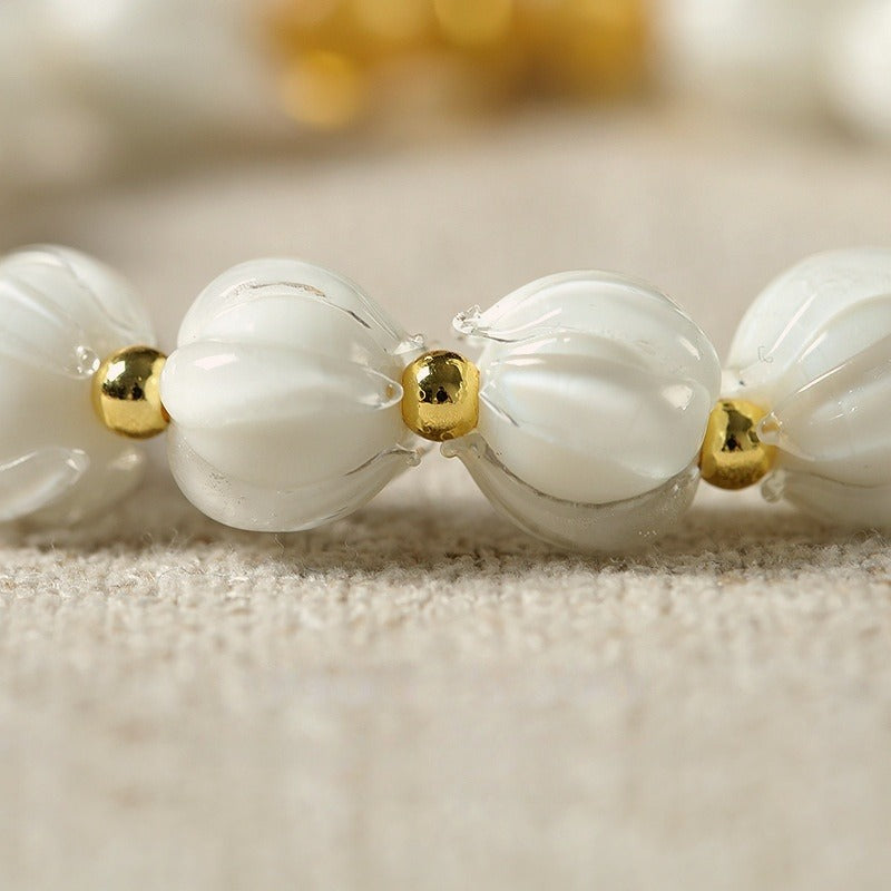 Bracelet: milky white lotus-shaped liuli glass beads with a Tunjin beast charm, second view