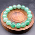 Bracelet: round green African Jade beads on a wooden dish