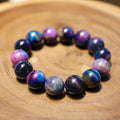 Bracelet: large pietersite beads with blue and violet shimmering bands, on a wooden surface
