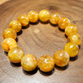 Bracelet: large golden-yellow hematoid quartz beads on a wooden surface