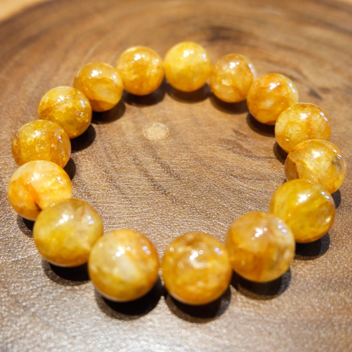 Bracelet: large golden-yellow hematoid quartz beads on a wooden surface