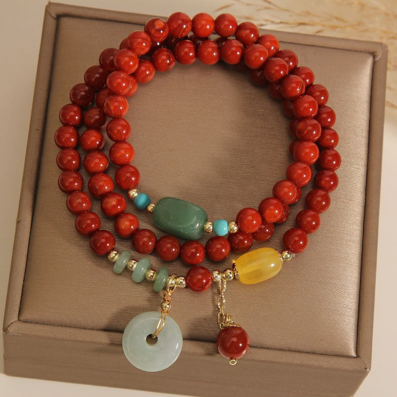 Bracelet: multi-wrap red agate beads with a pale jadeite circle pendant, third view