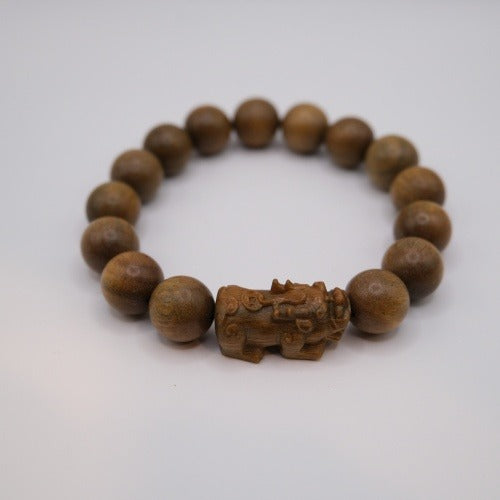 Bracelet: brown green sandalwood beads with one bead carved as a Pixiu, third view