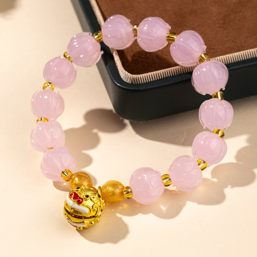 Bracelet: soft pink lotus-shaped liuli glass beads with a gold-coloured Tunjin beast charm