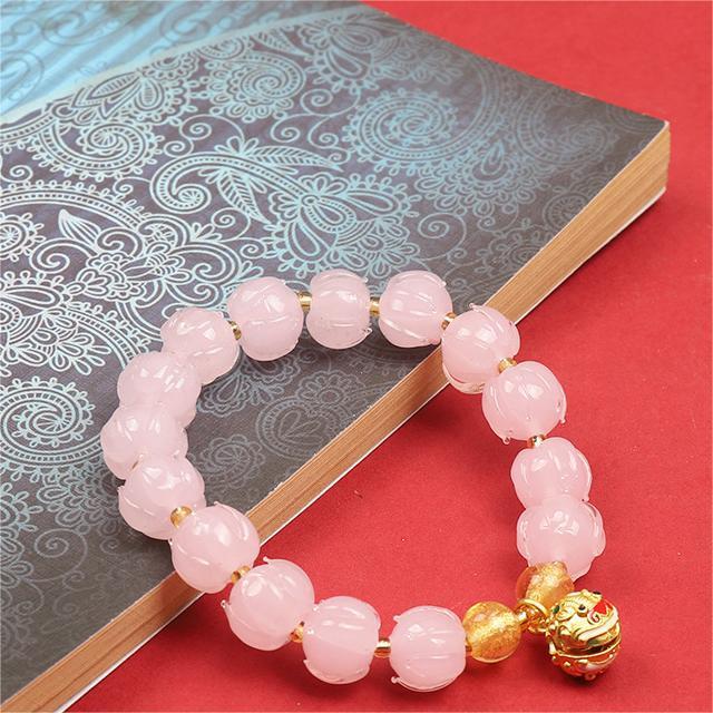 Bracelet: soft pink lotus-shaped liuli glass beads with a Tunjin beast charm, second view