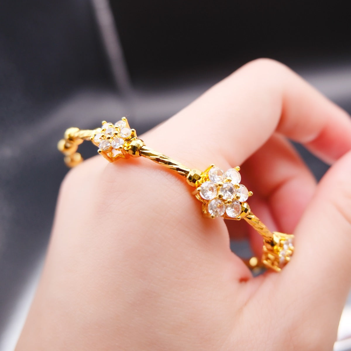 Bracelet: 18K gold plated twisted band with flower clusters of cubic zirconia, second view
