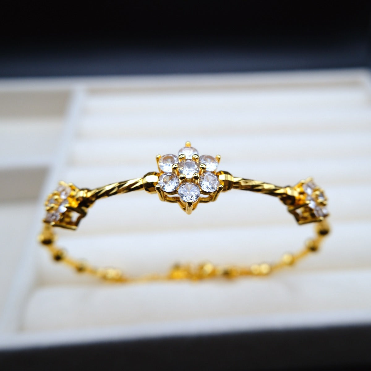 Bracelet: 18K gold plated twisted band with flower clusters of cubic zirconia, third view