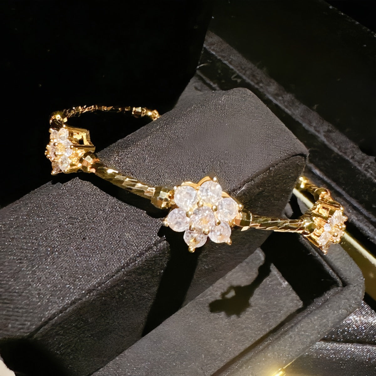 Bracelet: 18K gold plated twisted band with flower clusters of cubic zirconia, fourth view