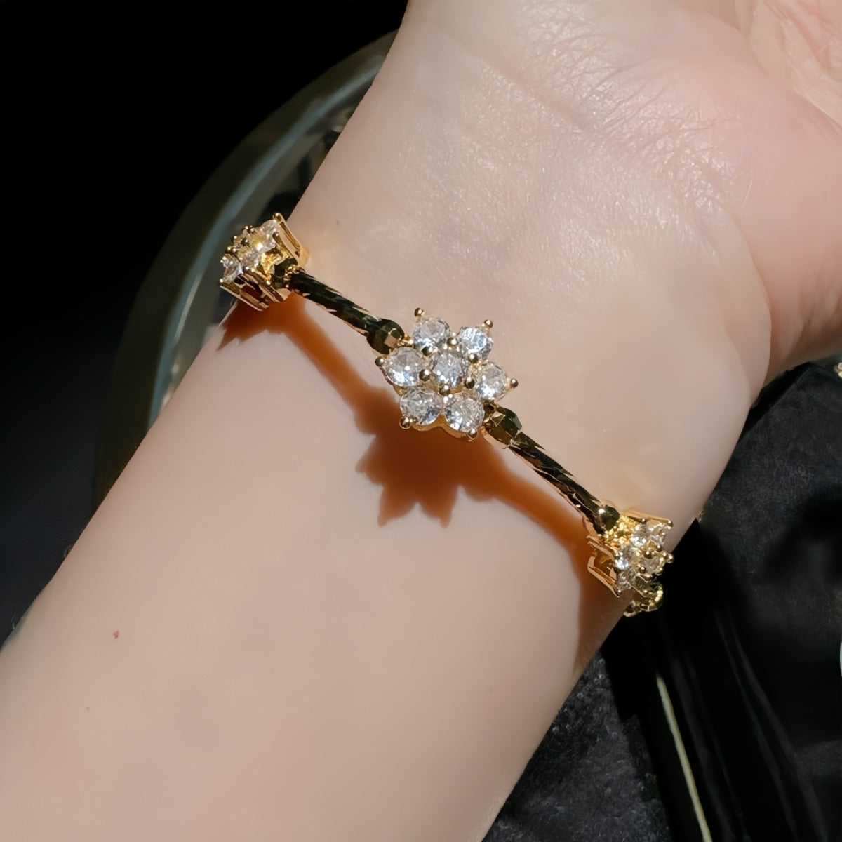 Bracelet: 18K gold plated twisted band with flower clusters of cubic zirconia, fifth view