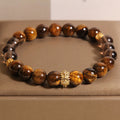 Bracelet: brown tiger's eye beads and smoky translucent beads with a gold-coloured carved metal accent