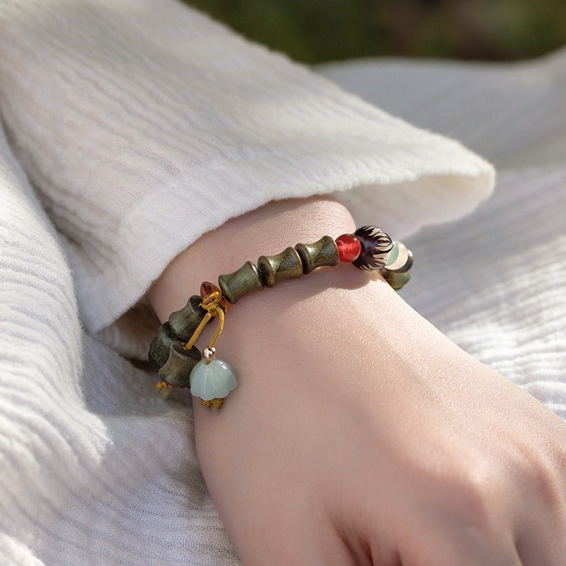 Bracelet: sandalwood beads shaped like bamboo segments, with a red cinnabar bead, second view