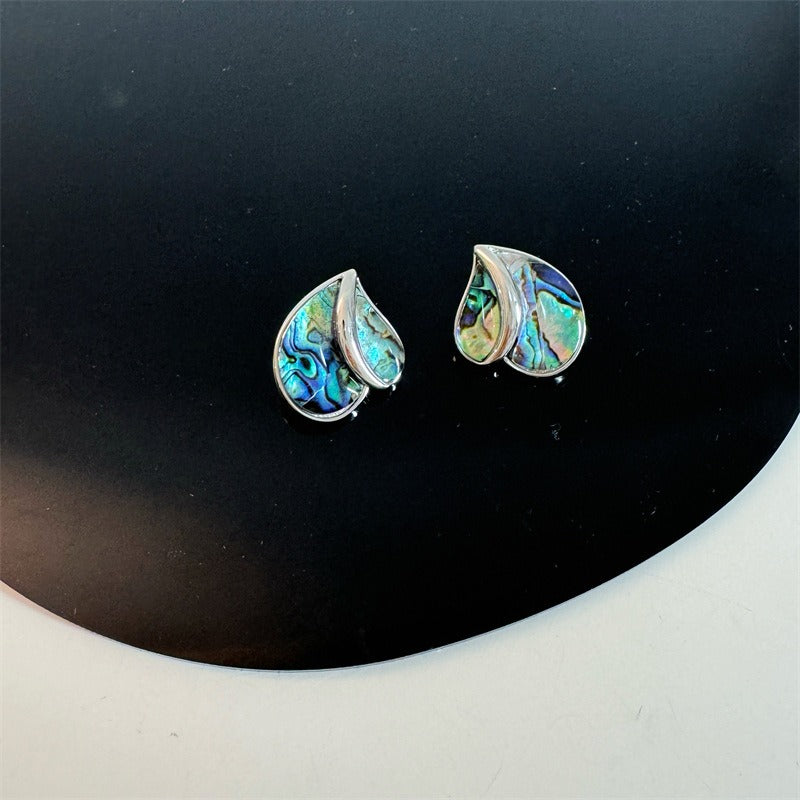 Earrings: iridescent green-blue mother-of-pearl teardrops in a silver frame, forming a heart shape