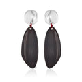 Earrings: long dark wood drops hung by red thread from round silver-coloured studs