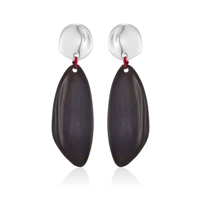 Earrings: long dark wood drops hung by red thread from round silver-coloured studs