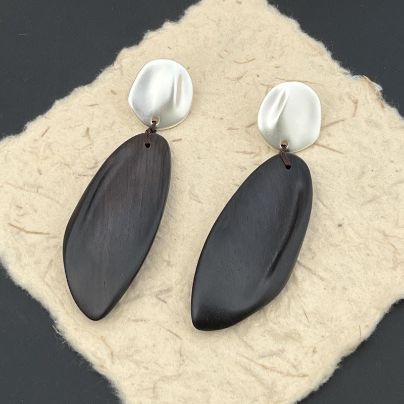 Earrings: long dark wood drops hung by red thread from round studs, third view
