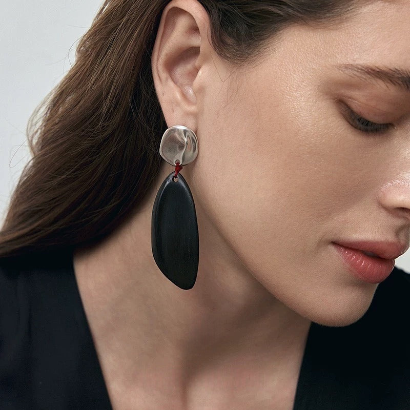 Earrings: long dark wood drops hung by red thread from round studs, fourth view