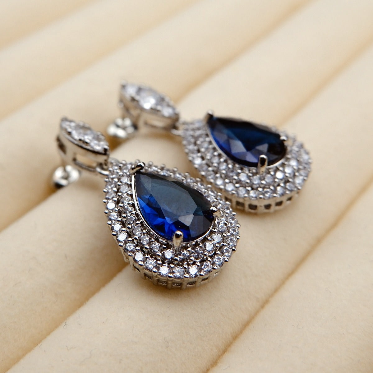 Earrings: royal blue pear-cut stones in halos of lab-created cubic zirconia, third view