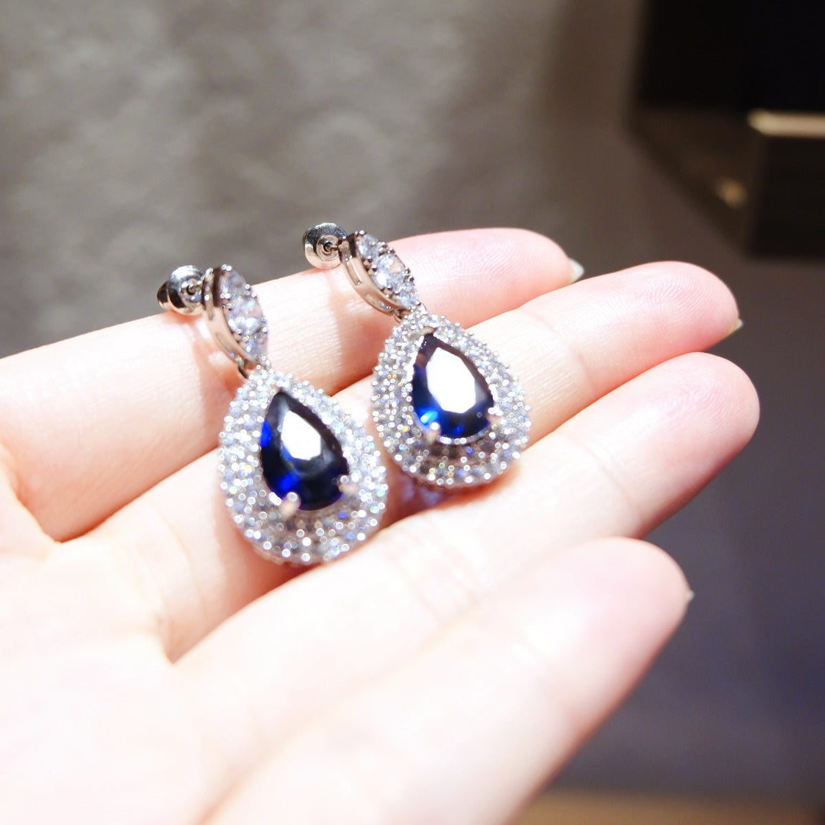 Earrings: royal blue pear-cut stones in halos of lab-created cubic zirconia, fifth view