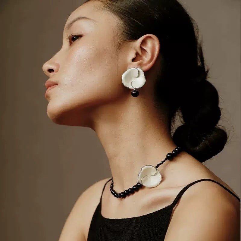 Earrings: white enamel crown of thorns flowers with a black agate bead drop, third view