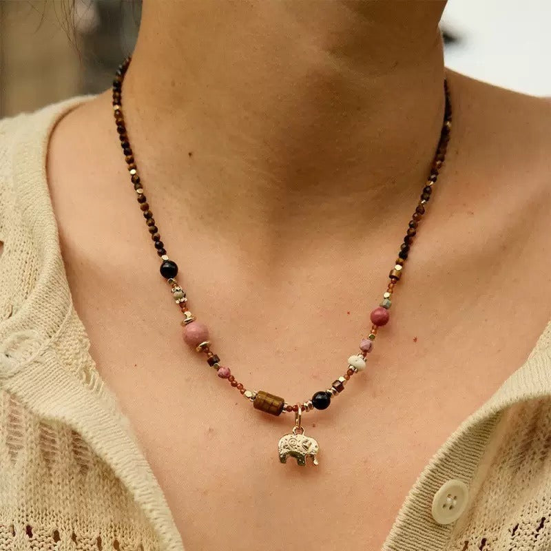Necklace: brown gemstone beads with pink and black accents and an elephant charm, second view
