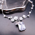 Necklace: clear emerald-cut stone below a butterfly on a 925 sterling silver floral vine chain