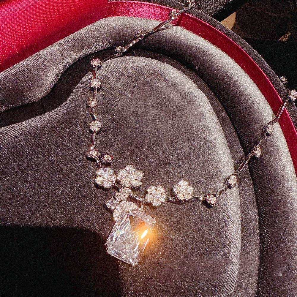 Necklace: clear emerald-cut cubic zirconia below a butterfly on a vine chain, third view