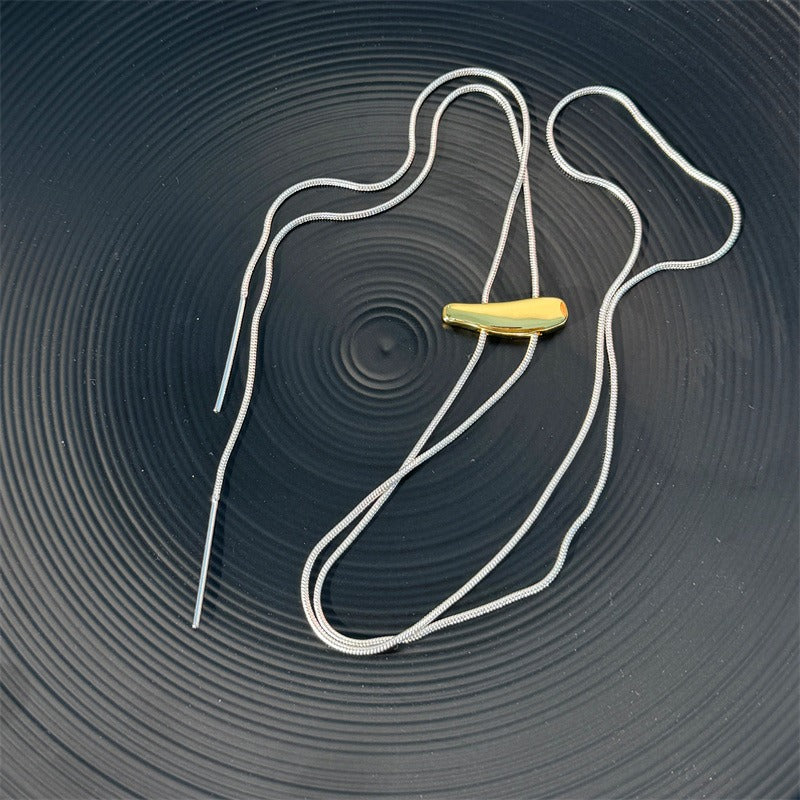 Necklace: long silver-coloured snake chain with a gold-coloured slider bar, on a dark round plate