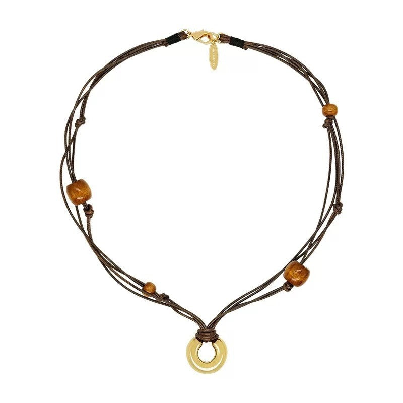 Necklace: layered brown leather cords with brown wood beads and a gold-tone ring pendant