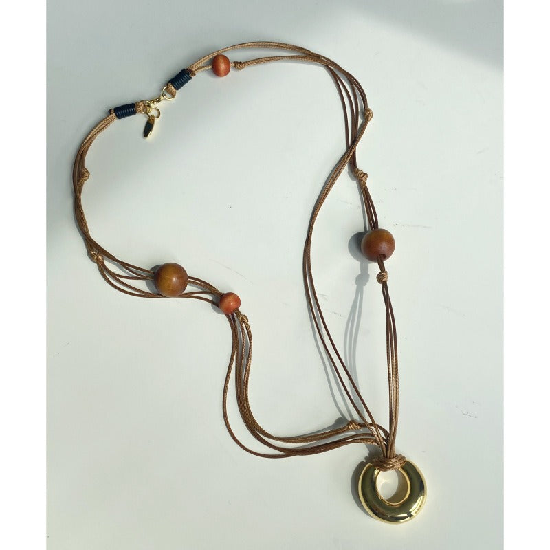 Necklace: layered brown leather cords with wood beads and a gold-tone ring, fifth view