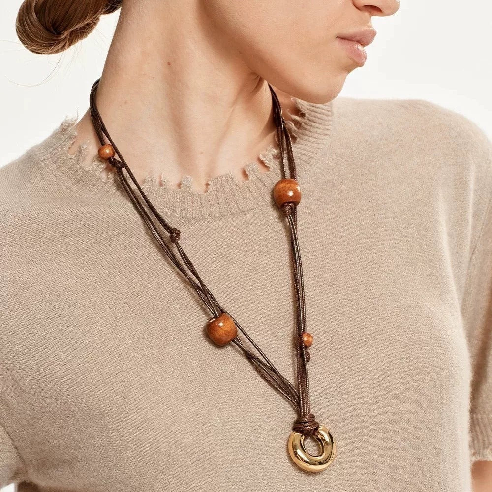 Necklace: layered brown leather cords with wood beads and a gold-tone ring, sixth view