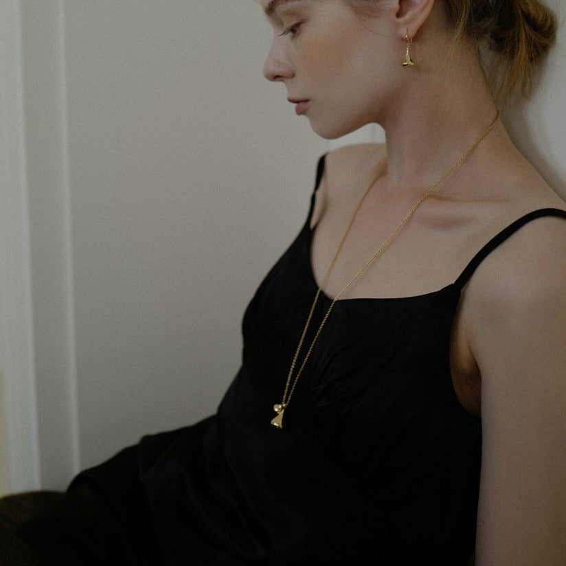 Necklace: long chain with two rounded sculptural drop pendants, third view