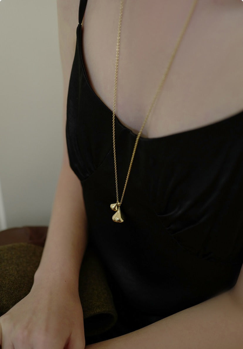 Necklace: long chain with two rounded sculptural drop pendants, fourth view
